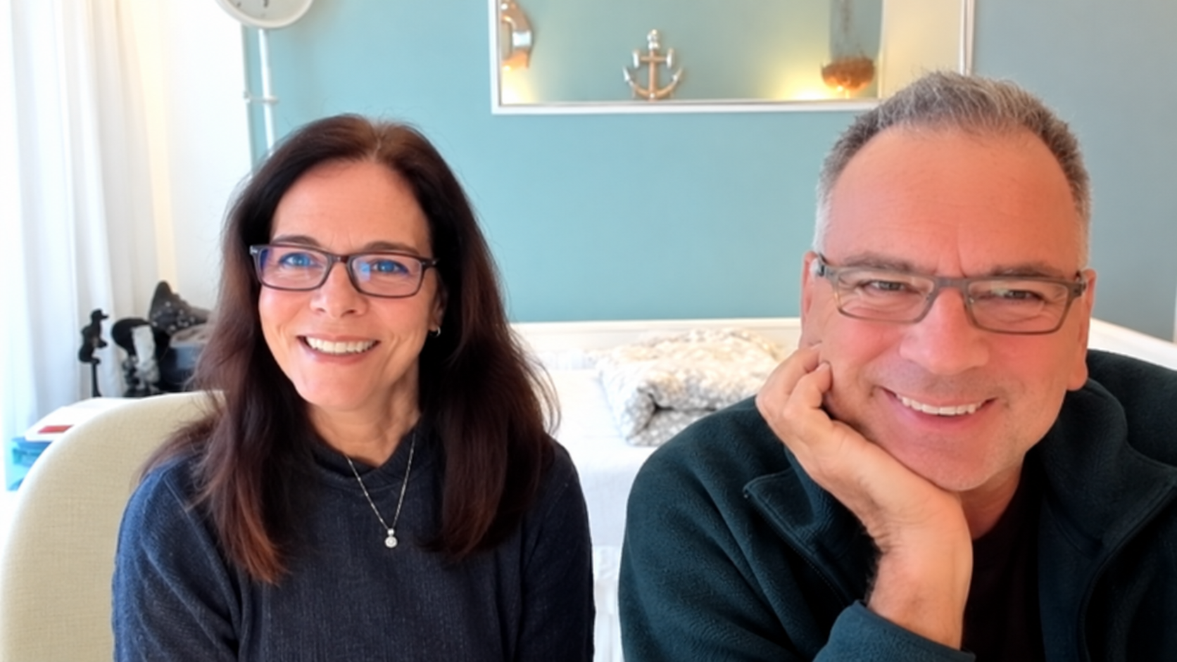 Ela und Oli von Denkzeuge sitzen nebeneinander und lächeln in die Kamera.